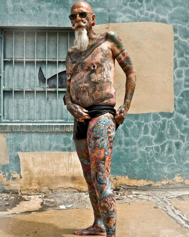 Un homme tatoué de la tête aux pieds