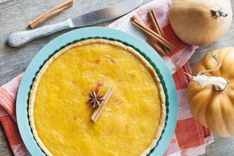 homemade spicy pumpkin pie with cinnamon in silicone bakeware on a table with pumpkins at background homemade spicy pumpkin pie with cinnamon in silicone bakeware on a table with pumpkins at background